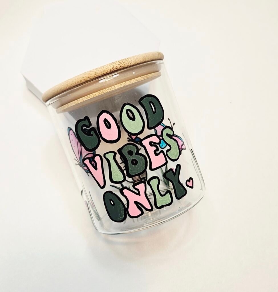 Selbst bemaltes Glas mit Bambusdeckel und dem Schriftzug „Good Vibes Only" in Rosa und Grün, aus dem Workshop Gläser bemalen in Wuppertal
