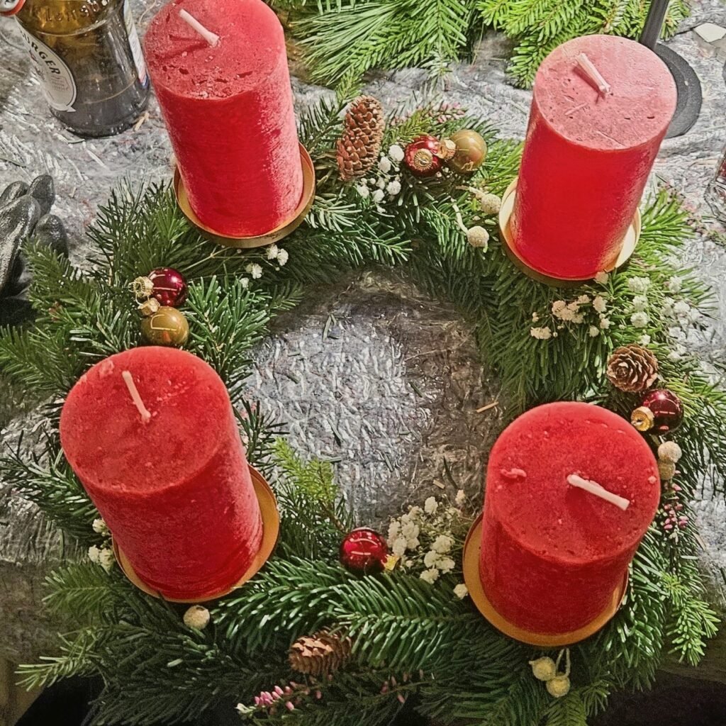 Adventskranz mit vier roten Stumpenkerzen, Zapfen, Schleierkraut und kleinen Christbaumkugeln, aus dem Workshop Adventskranz binden in Wuppertal