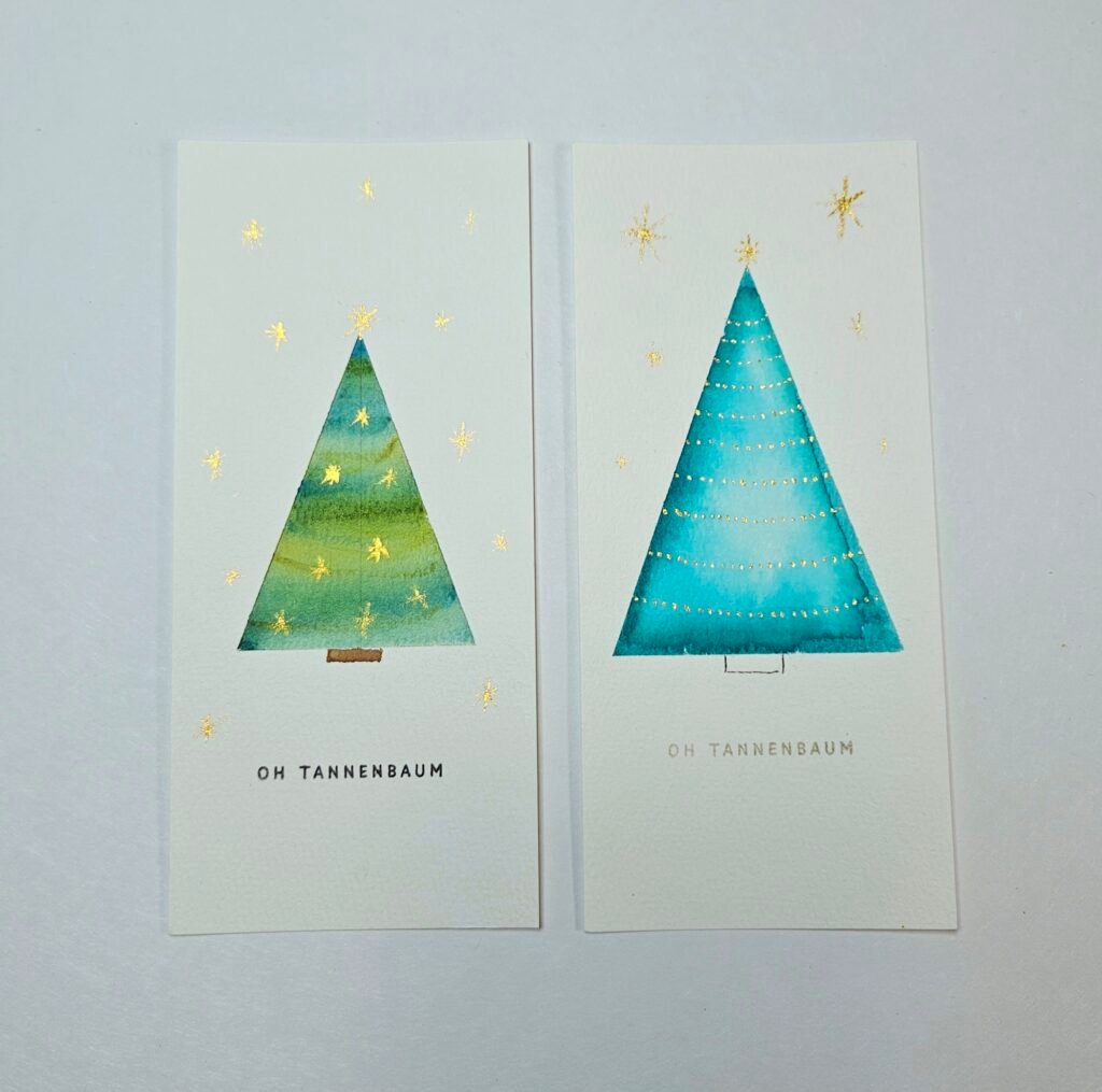 Zwei schmale Karten „Oh Tannenbaum“ mit Aquarell-Tannen in Grün und Türkis und goldenen Sternen