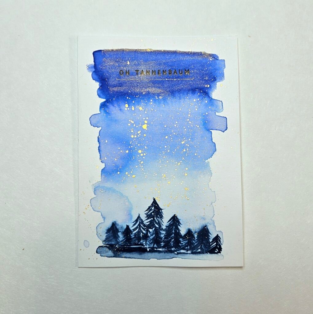 Aquarell-Nachthimmel in Blau mit Goldsprenkeln über dunklen Tannensilhouetten, Schriftzug „Oh Tannenbaum“