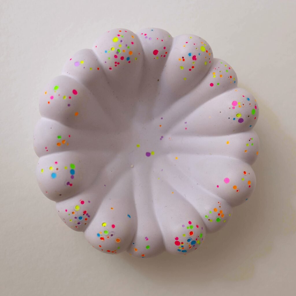Runde Schale aus Gießkeramik in Flieder mit geschwungenem Wellenrand und bunten Neon-Farbtupfen, aus dem Workshop Gießkeramik in Wuppertal