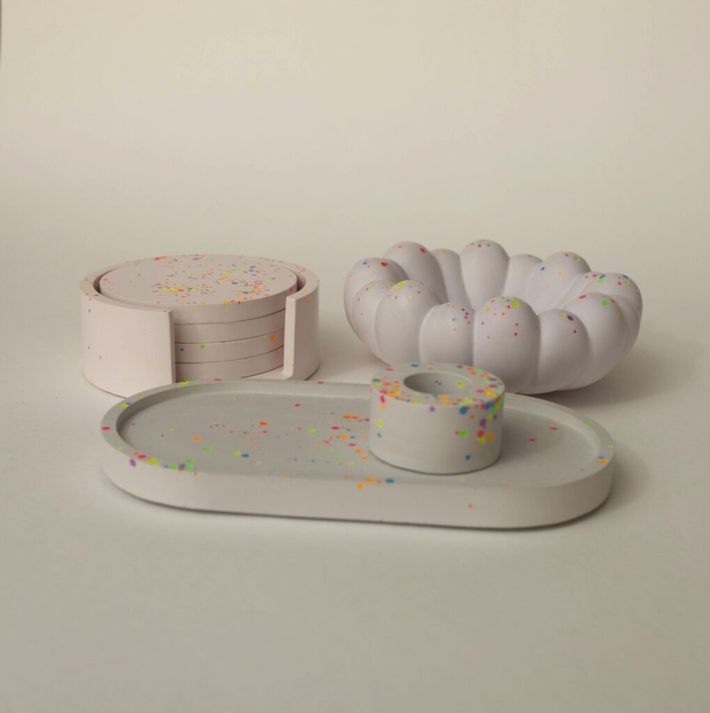 Set aus Gießkeramik mit Untersetzern im Halter, Wellenschale, ovalem Tablett und Kerzenhalter mit Neon-Farbtupfen, aus dem Workshop Gießkeramik in Wuppertal