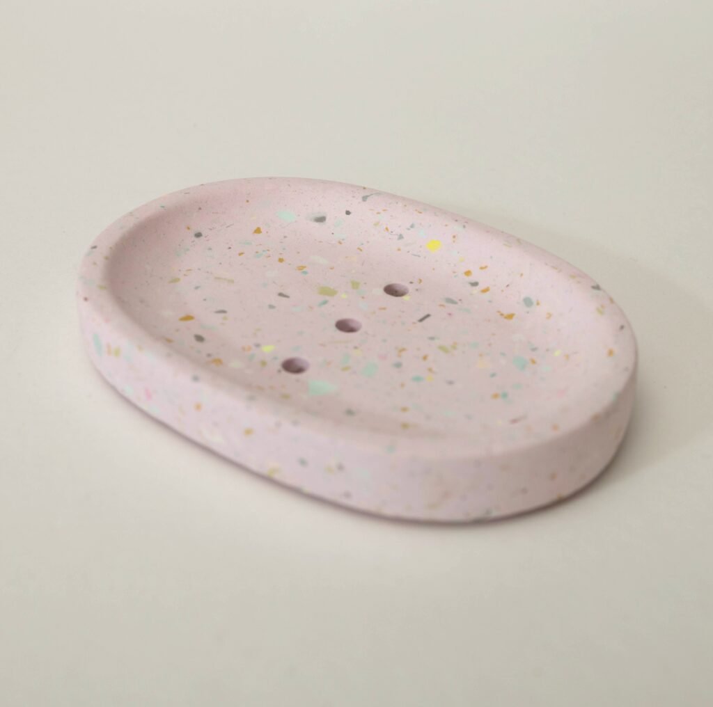 Ovale Seifenschale aus Gießkeramik in Rosé mit feinem Terrazzo-Muster in Mint und Gelb, aus dem Workshop in Wuppertal