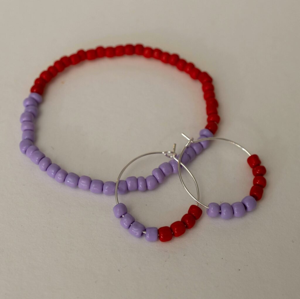 Schmuckset aus Perlenarmband und silbernen Creolen mit Rocailles in Flieder und Rot