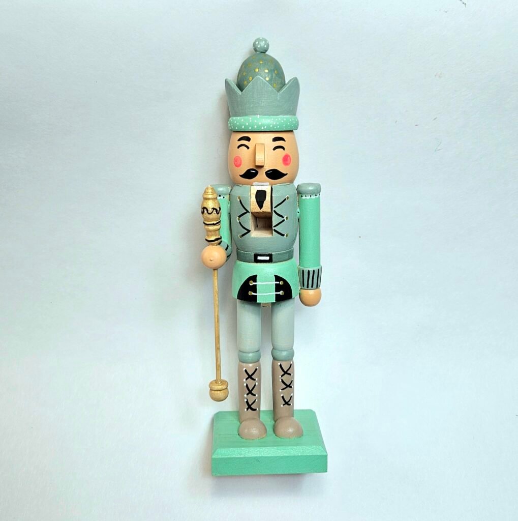 Bemalter Nussknacker in Mint und Salbeigrün mit goldenem Zepter, Krone mit Goldpunkten und schwarzem Schnurrbart