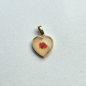 Muttermilchschmuck: kleiner Herz-Anhänger mit eingegossener roter Trockenblüte in Gold, aus dem Workshop in Wuppertal